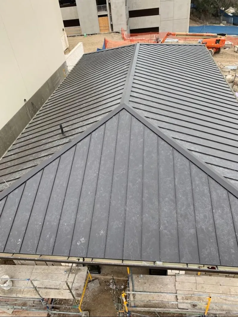 Commercial metal roof construction with crane equipment in Homewood