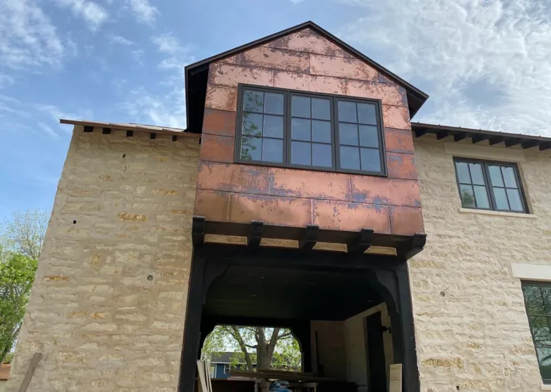Copper metal panel facade on a stone building for Skylight Installation in Homewood